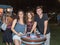 Young people joyfully posing near a decorative beer cask at the traditional annual beer festival in Haifa, Israel