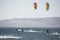 young people kitsurfing in a paracas bay of peru with blue water and drops in the air and mountains in the background-june 2020