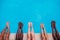 Young people lying near swimming pool. Cropped image of legs over blue water