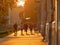 Young people merrily walking down the sidewalk in the rays of July sunset