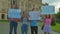 Young people protesting, holding placards with inscriptions outdoors