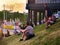 Young people sit on the grass waiting for the race cars to show up