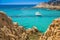 Young people snorkeling on Sardinia island with red stones near Chia beach