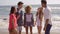 Young People Standing On The Beach.