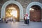 Young people taking photos with mobile phone in front of the ancient city gate at sunset time