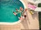 Young people toasting with bear in swimming pool