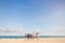 Young people walking on the beach carrying a cooler box