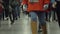 Young people walking in long corridor at airport terminal or railway station