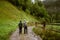 Young people wearing trekking equipment hiking in mountain forest