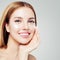 Young perfect smiling woman with healthy skin applying cream on her face, closeup portrait. Skin care and facial treatment concept