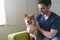 Young pet owner sitting on the couch at home with his best friend, Shiba Inu dog