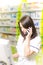 Young pharmacist woman expressing wonder while having a phone call. Pharmaceutical background. Drugstore. Pills and medicine.