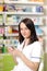 Young pharmacist woman using a app on a smart phone Pharmaceutical background. Drugstore. Pills and medicine.