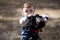 Young photographer child taking photos with camera on a tripod