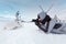 A young photographer shoots a white and cute deer lying on the snow. Very cold. Russia, Siberia, Yamal.