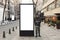 Young photographer stands in front of an empty billboard while taking pictures on the street