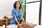 Young physiotherapist woman giving massage to african american man at the clinic