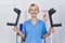 Young physiotherapist woman holding crutches smiling with a happy and cool smile on face