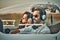 Young pilot and beautiful stewardess sitting together inside airplane cabin waiting for take off