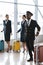 young pilot and stewardesses with luggage walking