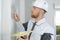 Young plasterer using spatula