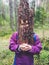 Young playful girl holding a piece of tree bark as face mask