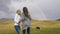 Young playful girls near a pastoral landscape field with cows taking a selfie photo with rainbow in background -