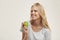 Young pleased european girl holding green apple