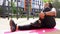 young plus size black african womanstretching body on mat outdoors alone, side view