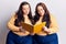 Young plus size twins holding book thinking attitude and sober expression looking self confident