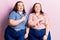 Young plus size twins wearing casual clothes pointing aside worried and nervous with both hands, concerned and surprised