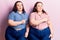 Young plus size twins wearing casual clothes pointing aside worried and nervous with forefinger, concerned and surprised