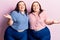Young plus size twins wearing casual clothes smiling showing both hands open palms, presenting and advertising comparison and