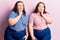 Young plus size twins wearing casual clothes touching mouth with hand with painful expression because of toothache or dental