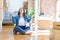 Young plus size woman sitting on the floor around cardboard boxes moving to a new home relax and smiling with eyes closed doing