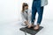 Young podiatrist in her clinic examining a patient`s feet on a pressure platform.