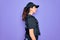 Young police woman wearing security bulletproof vest uniform over purple background looking to side, relax profile pose with