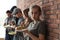 Young poor woman and other people with food at brick wall