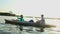 Young positive couple paddling kayak at sunset, beautiful view