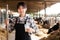 Young positive female dairy farm worker standing with glass of fresh milk