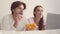Young positive married couple enjoying chips, watching tv online, lying in bed, close up portrait, slow motion