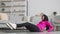 Young positive middle eastern woman in hijab practicing abdominal muscles workout, lying on floor and doing crunches