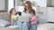 Young positive mother trying to work on laptop with children at home