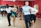 Young positive people dancing vigorous jive movements in dance studio