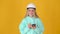 Young positive thinking girl builder in helmet with phone and pen in hands