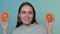 Young positive woman with healthy skin posing with grapefruit isolated over blue wall background.