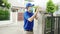 Young postal delivery courier man wear face mask handling food box for send to customer at house and Asian female receive