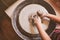 Young potter hands working with clay on pottery wheel