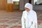 Young praying woman falling on knees in mosque