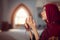 Young praying woman falling on knees in mosque